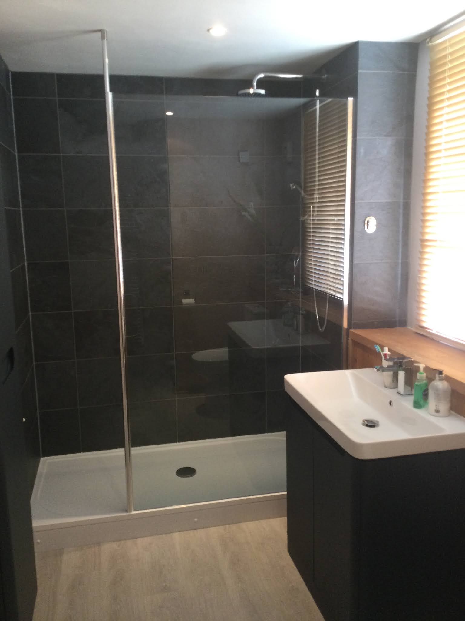 Walk-in shower with dark slate-effect tiles and a charcoal vanity unit